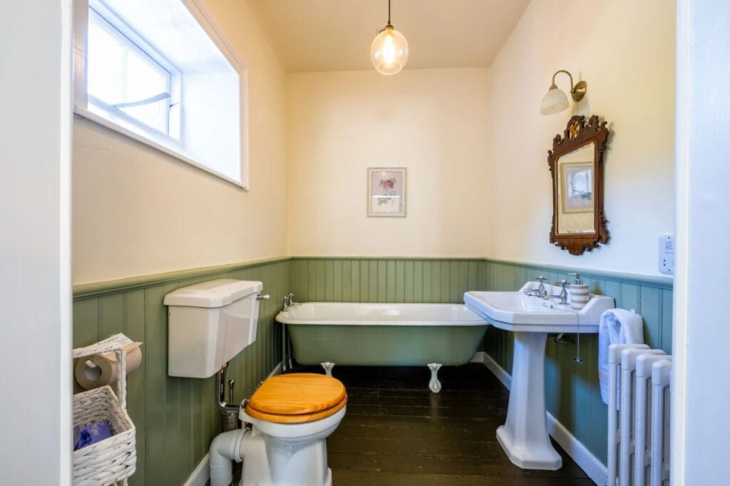 Vintage bathroom with green paneling.